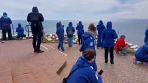 Reisebüromitarbeiter in blauen Jacken beobachten Basstölpel auf Helgoland